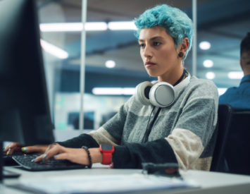 In Diverse Multi-Ethnic Office: Portrait of Young Stylish Woman Working on Desktop Computer. Non-Binary Person Creating Modern Content, Do Contemporary Project Design, Create Colorful Marketing